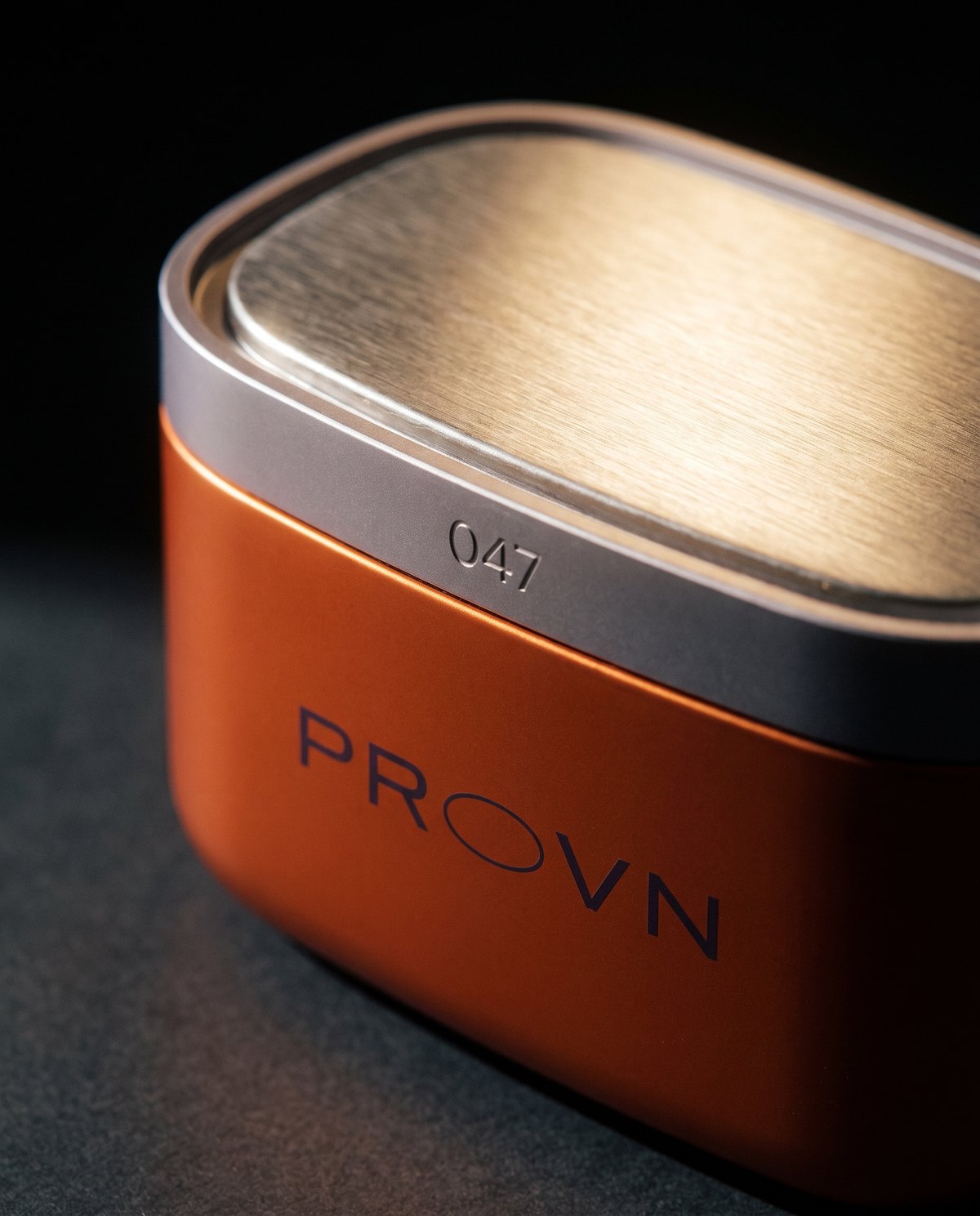 The brushed silver lid of the orange Provn tin, numbered 047